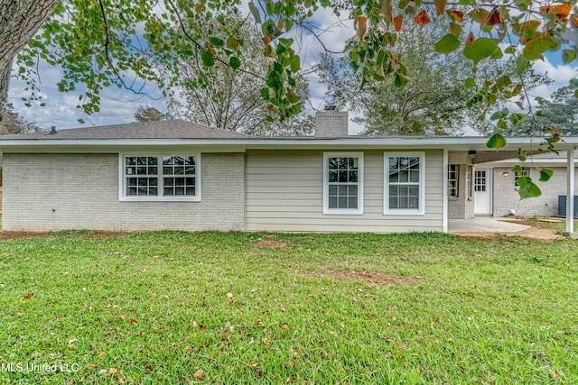 rear view of property featuring a yard