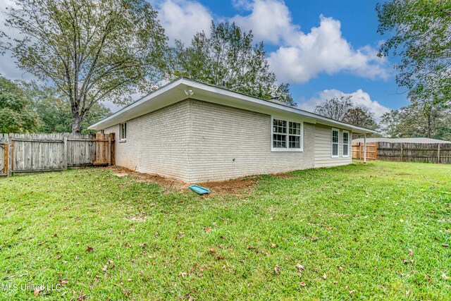 rear view of property featuring a lawn