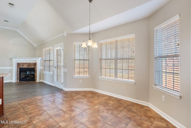 unfurnished dining area featuring a notable chandelier, a wealth of natural light, lofted ceiling, and ornamental molding