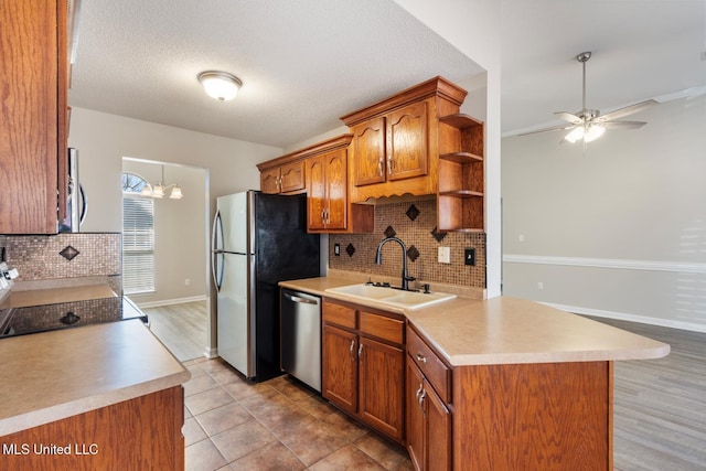 kitchen featuring sink, a textured ceiling, appliances with stainless steel finishes, and tasteful backsplash