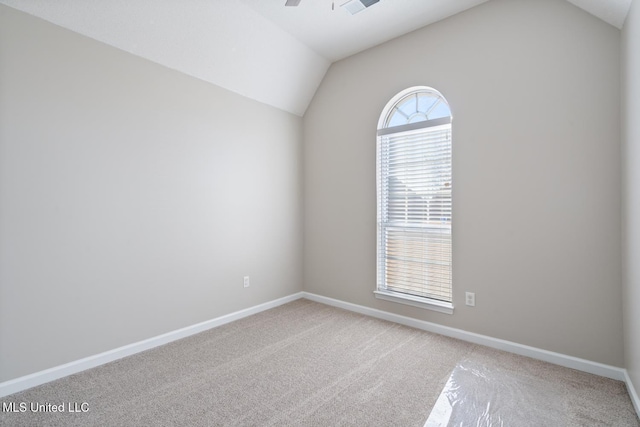 empty room featuring ceiling fan, carpet floors, and lofted ceiling