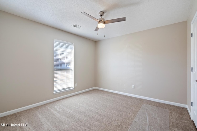 carpeted empty room with ceiling fan and a textured ceiling