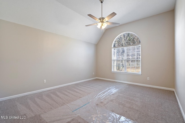 carpeted spare room with ceiling fan and lofted ceiling