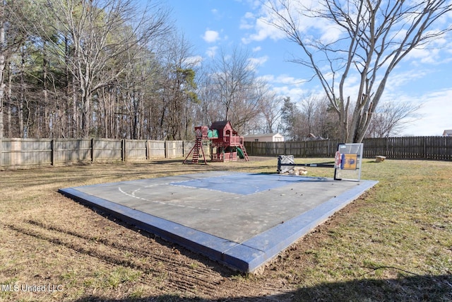 view of basketball court featuring a playground and a lawn