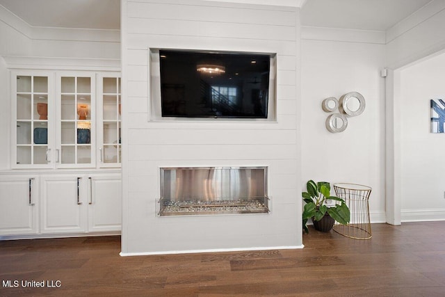 unfurnished living room featuring ornamental molding and dark hardwood / wood-style flooring