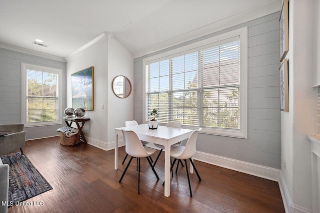 dining room featuring crown molding, plenty of natural light, and dark hardwood / wood-style floors