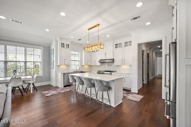 kitchen with white cabinetry, appliances with stainless steel finishes, plenty of natural light, and a kitchen island