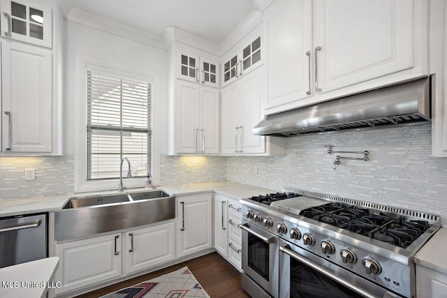 kitchen featuring white cabinets, backsplash, appliances with stainless steel finishes, light stone countertops, and sink