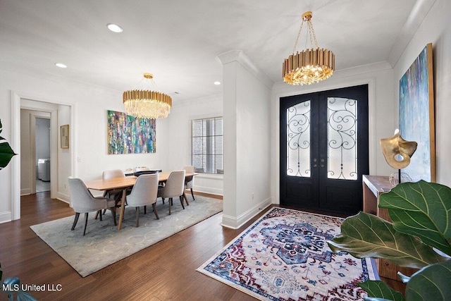 entryway with french doors, crown molding, dark hardwood / wood-style floors, and a chandelier