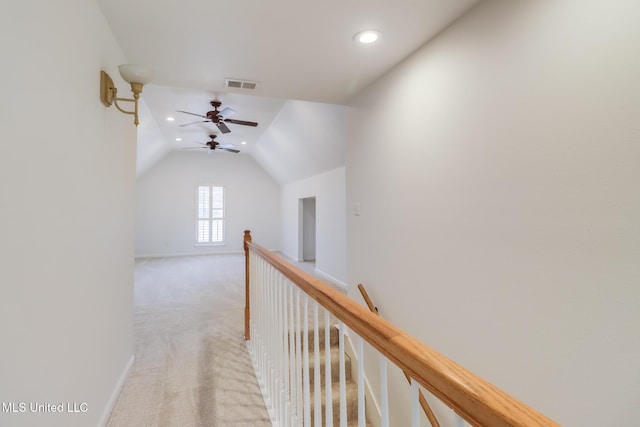 corridor featuring lofted ceiling and light colored carpet