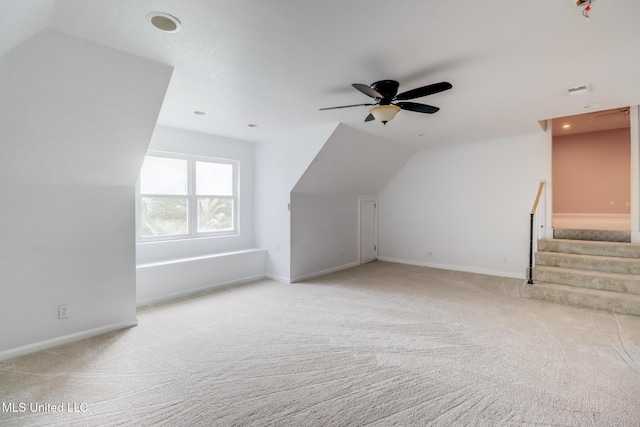 additional living space with vaulted ceiling, light colored carpet, and ceiling fan