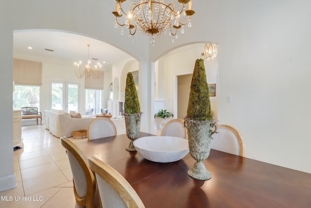 dining area featuring an inviting chandelier, light tile patterned floors, and french doors