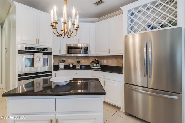 kitchen with white cabinetry, decorative light fixtures, a notable chandelier, stainless steel appliances, and decorative backsplash