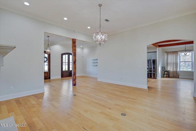 empty room with ornamental molding and light hardwood / wood-style floors