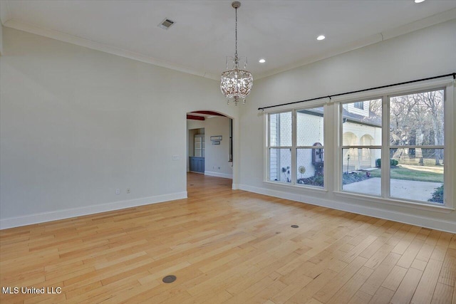 unfurnished room with a chandelier, a wealth of natural light, crown molding, and light hardwood / wood-style flooring