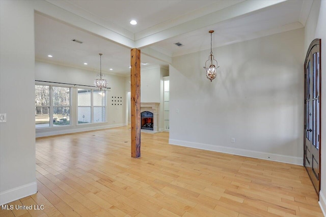 unfurnished living room featuring light hardwood / wood-style floors and crown molding