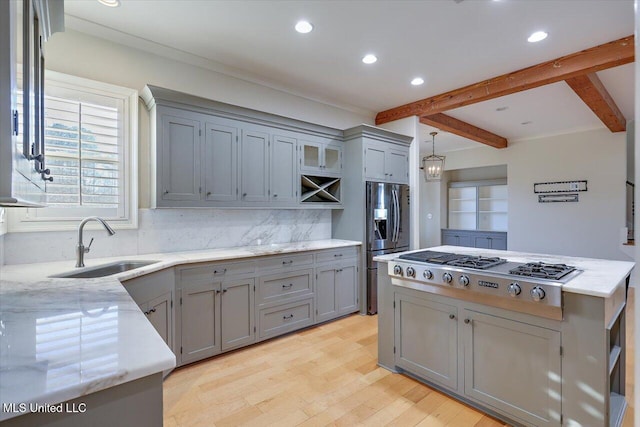 kitchen featuring sink, appliances with stainless steel finishes, decorative backsplash, pendant lighting, and beam ceiling