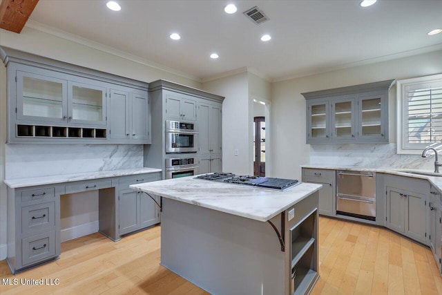 kitchen with a kitchen island, stainless steel appliances, sink, and decorative backsplash