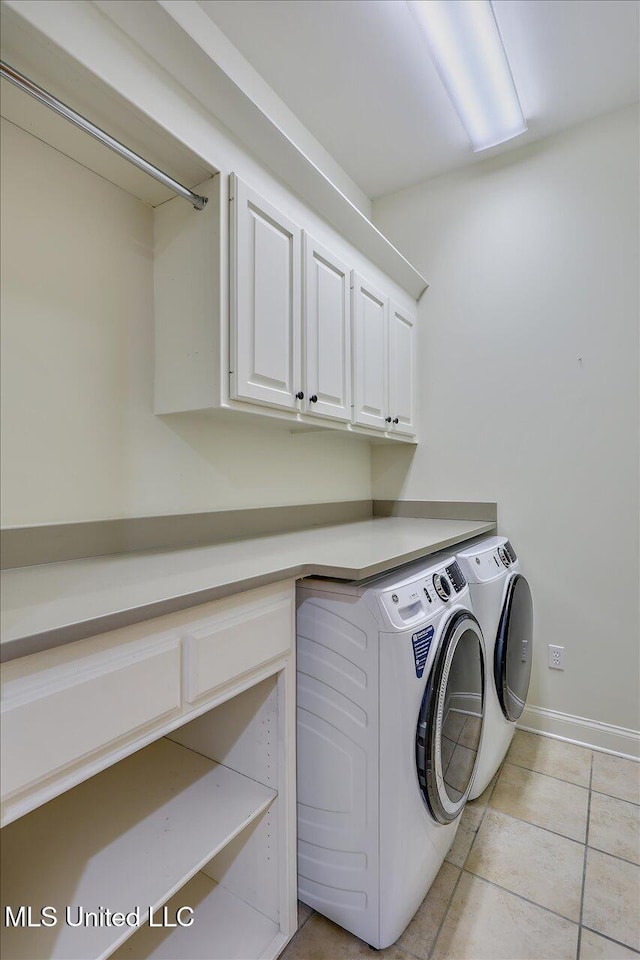 clothes washing area featuring independent washer and dryer, cabinets, and light tile patterned floors