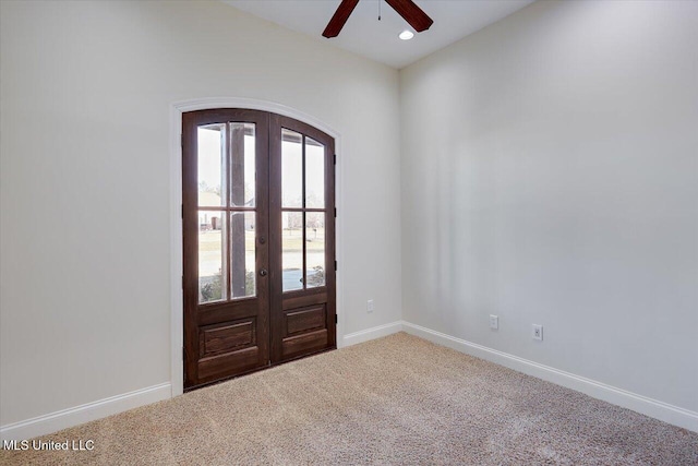 carpeted entrance foyer with ceiling fan and french doors