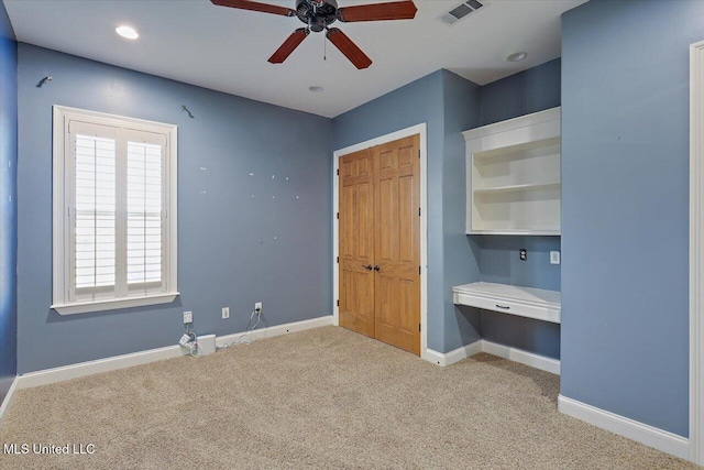 unfurnished bedroom with ceiling fan, a closet, and light carpet