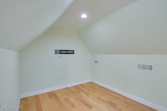 additional living space featuring vaulted ceiling and hardwood / wood-style floors