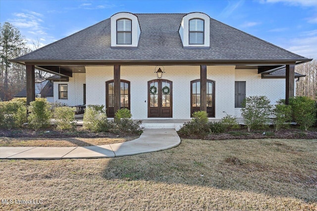 french country style house featuring a porch, french doors, and a front lawn