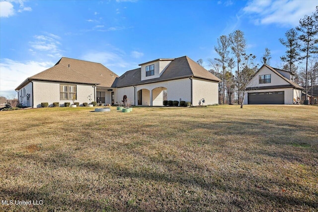 back of house featuring a lawn and a garage