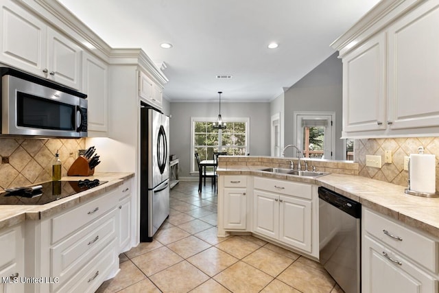 103 Maple Grv, Madison, MS 39110 - kitchen with appliances with stainless steel finishes, light tile patterned flooring, crown molding, a peninsula, and white cabinetry