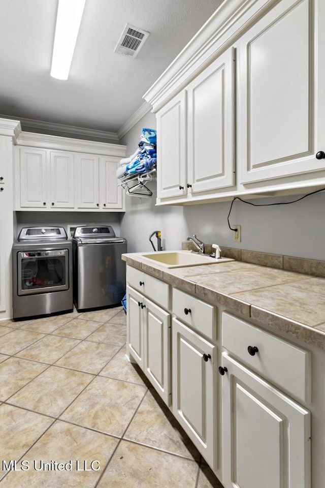 103 Maple Grv, Madison, MS 39110 - laundry room with washer and clothes dryer, cabinet space, ornamental molding, and light tile patterned floors