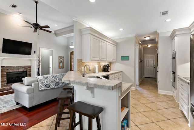 103 Maple Grv, Madison, MS 39110 - kitchen featuring a peninsula, a ceiling fan, open floor plan, a kitchen breakfast bar, and light tile patterned floors