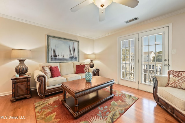 living room with crown molding, ceiling fan, and wood-type flooring