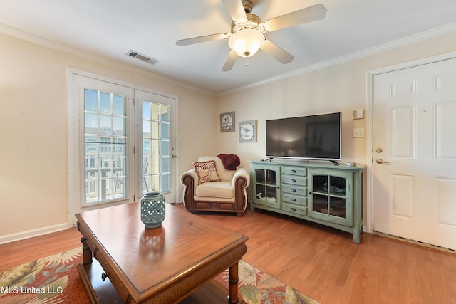 living room featuring wood-type flooring, ceiling fan, and crown molding