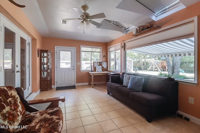 tiled living room with ceiling fan and french doors