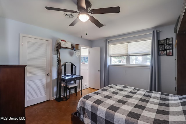 bedroom with ceiling fan and dark parquet floors