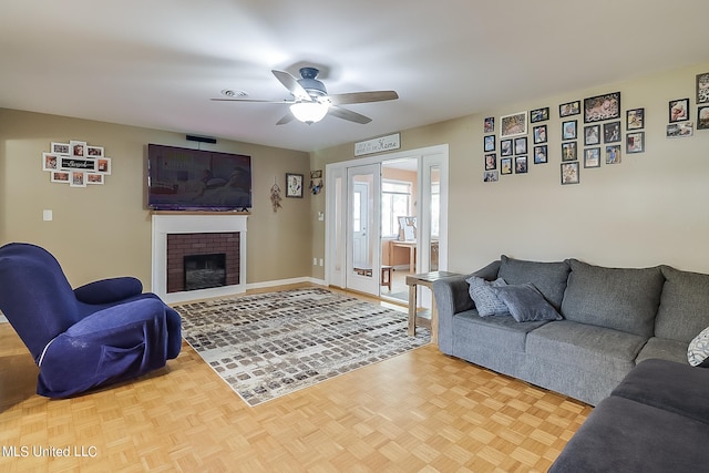 living room featuring a brick fireplace, parquet floors, and ceiling fan