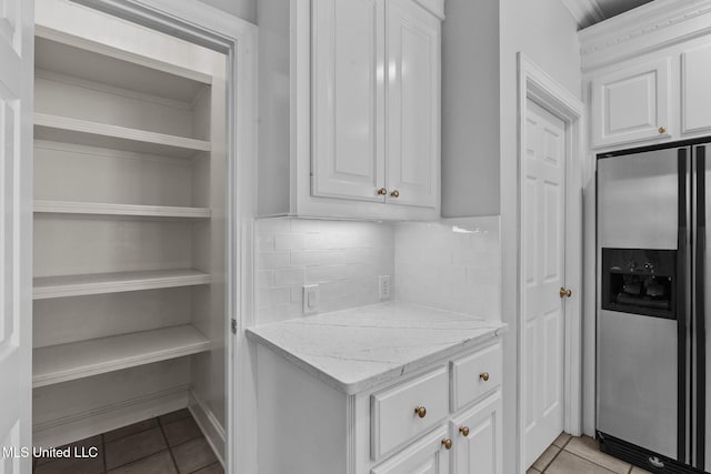 706 Danforth Dr, Madison, MS 39110 - kitchen with stainless steel refrigerator with ice dispenser, white cabinetry, light tile patterned flooring, and light stone counters
