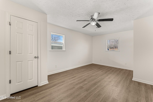 spare room featuring a textured ceiling, ceiling fan, and wood-type flooring