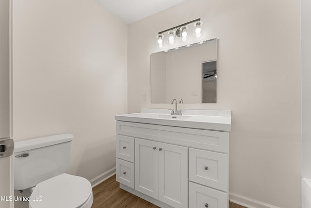 bathroom featuring toilet, vanity, and hardwood / wood-style flooring