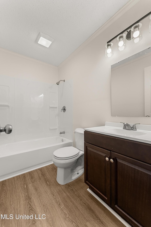 full bathroom with toilet, bathing tub / shower combination, hardwood / wood-style floors, a textured ceiling, and crown molding