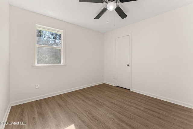 empty room with ceiling fan and dark wood-type flooring