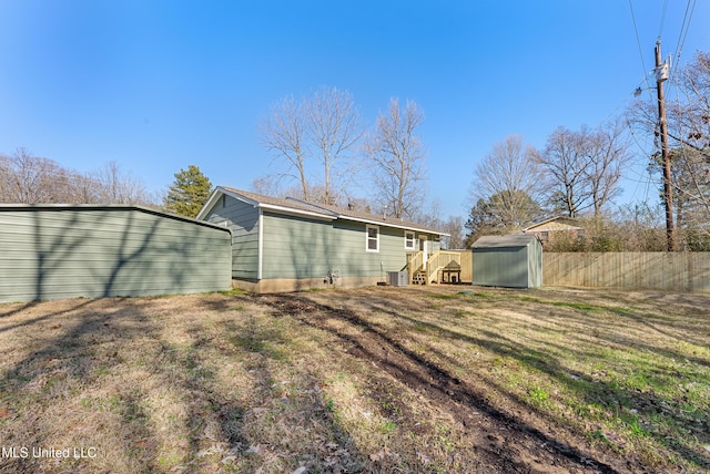 back of house featuring a yard and a storage unit