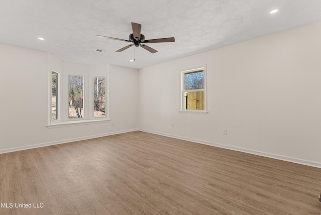 unfurnished room featuring ceiling fan, a textured ceiling, and wood-type flooring