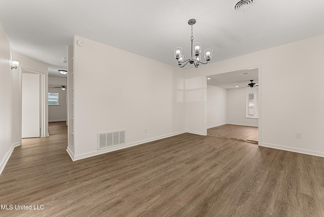 spare room with dark wood-type flooring and a notable chandelier