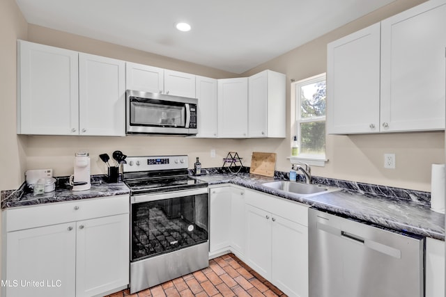 101 30th St, Gulfport, MS 39507 - kitchen with stainless steel appliances, a sink, dark countertops, white cabinets, and recessed lighting