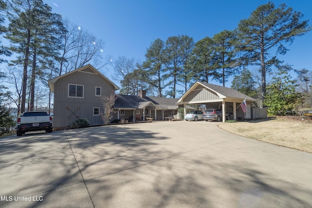 view of side of property featuring an attached carport and concrete driveway