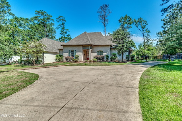 2024 E Northside Dr, Jackson, MS 39211 - french country home with fence, concrete driveway, a front lawn, and stucco siding