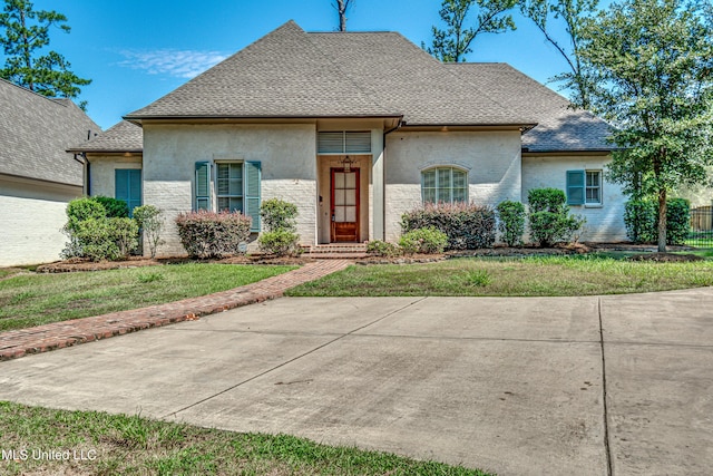 2024 E Northside Dr, Jackson, MS 39211 - french provincial home featuring a front lawn, roof with shingles, and stucco siding