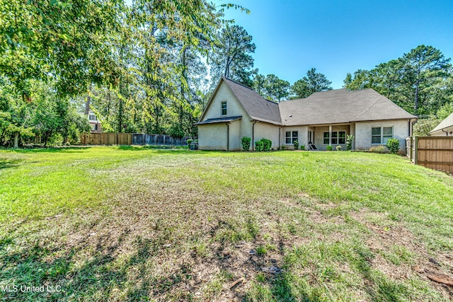 2024 E Northside Dr, Jackson, MS 39211 - rear view of property with stucco siding, fence, and a lawn