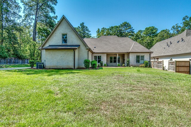 2024 E Northside Dr, Jackson, MS 39211 - back of property featuring stucco siding, central air condition unit, a lawn, and fence
